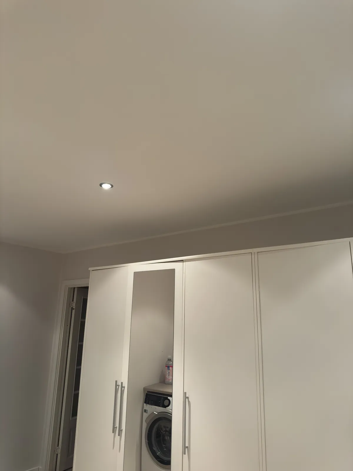 Bryggers med hvide skabslåger og nymalet loft